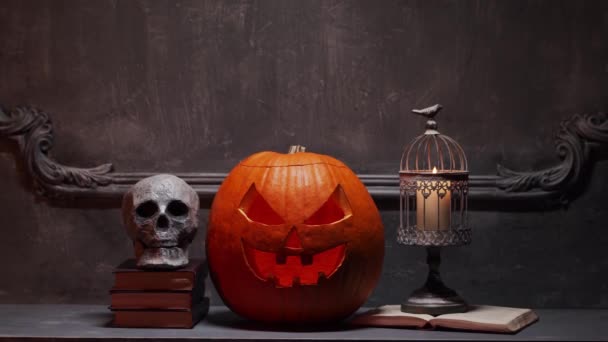 Gruselig lachender Kürbis und alter Totenkopf auf altem gotischen Kamin. Halloween, Hexerei und Magie. — Stockvideo