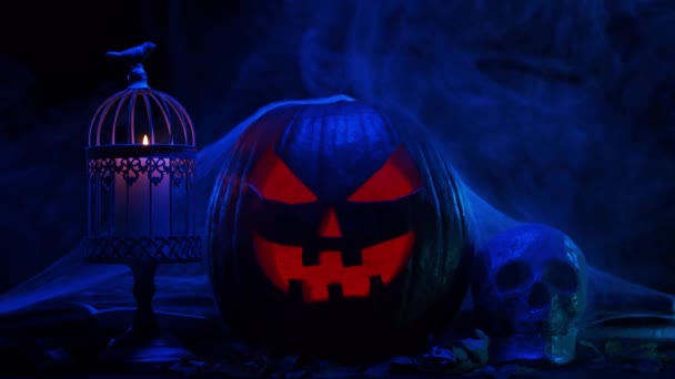 Ijesztő nevető tök és egy öreg koponya sötét háttérrel. Halloween, boszorkányság és varázslat. — Stock videók