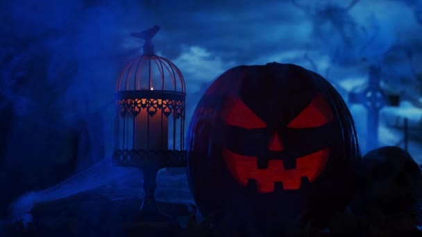 Skrattande pumpa och en gammal skalle över den skrämmande gotiska kyrkogården bakgrund. Halloween, häxeri och magi. — Stockvideo