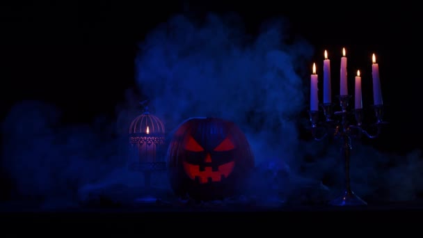 Skrattande pumpa och en gammal skalle med mörk bakgrund. Halloween, häxeri och magi. — Stockvideo