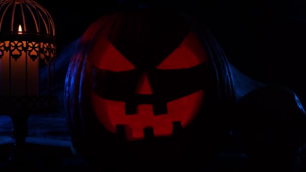 Skrattande pumpa och en gammal skalle med mörk bakgrund. Halloween, häxeri och magi. — Stockvideo