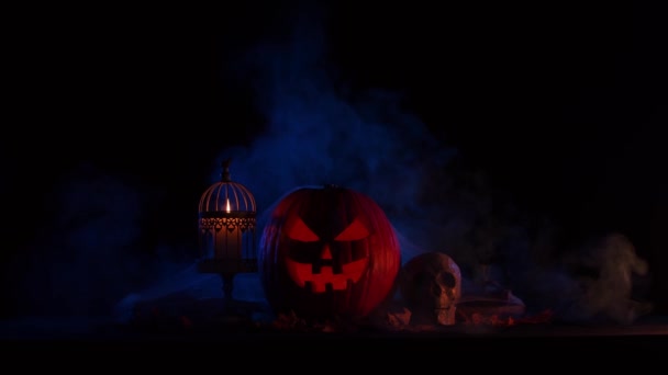 Przerażająca dynia i stara czaszka na ciemnym tle. Halloween, czary i magia. — Wideo stockowe