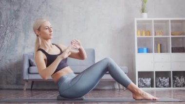 Spor giyimli genç ve sportif kız iç mekanda egzersiz yapıyor. Formda ve narin sarışın kadın spor ve spor için geliyor. Sağlık sigortası, yağ yakma ve sağlık..