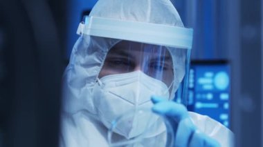 Koruyucu kıyafetli doktor modern bir laboratuvarda bilimsel deneyler yapıyor ve aşı geliştiriyor. Laboratuvar asistanı iş yerinde. Bilim ve tıp kavramı.