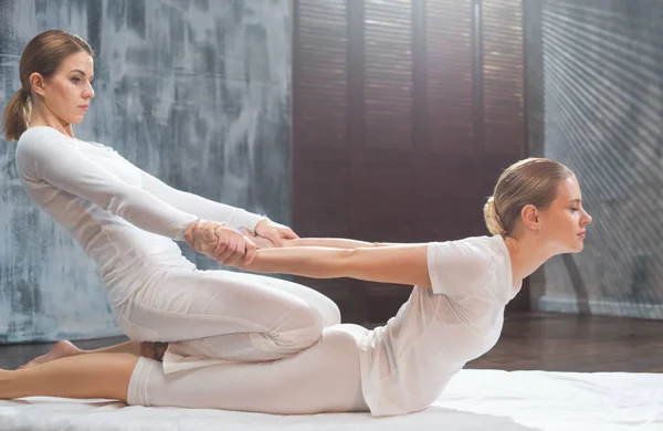 Professionell massör som utför thaimassage. Terapeut gör body stretching övningar till kunden i ett traditionellt spa. Hälso- och sjukvårdskoncept. — Stockfoto