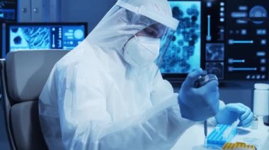 Koruyucu kıyafetli doktor modern bir laboratuvarda bilimsel deneyler yapıyor ve aşı geliştiriyor. Laboratuvar asistanı iş yerinde. Bilim ve tıp kavramı.