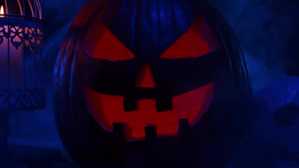 Abóbora risonha assustadora e um crânio velho num fundo escuro. Halloween, bruxaria e magia. — Vídeo de Stock