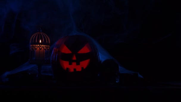 Děsivá dýně a stará lebka na tmavém pozadí. Halloween, čarodějnictví a magie. — Stock video