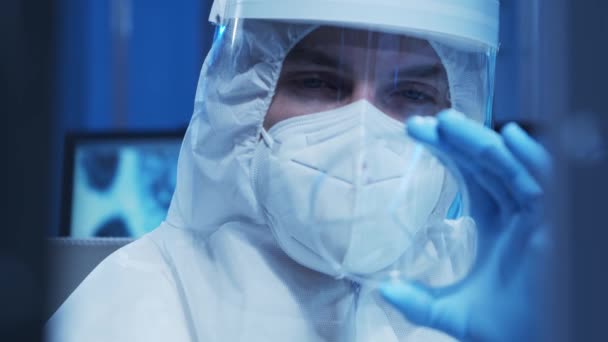 Koruyucu kıyafetli doktor modern bir laboratuvarda bilimsel deneyler yapıyor ve aşı geliştiriyor. Laboratuvar asistanı iş yerinde. Bilim ve tıp kavramı. — Stok video