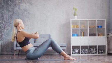 Spor giyimli genç ve sportif kız iç mekanda egzersiz yapıyor. Formda ve narin sarışın kadın spor ve spor için geliyor. Sağlık sigortası, yağ yakma ve sağlık..