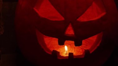 Karanlık bir arka planda korkutucu, gülen bir balkabağı. Cadılar Bayramı, büyücülük ve sihir.