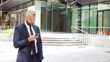 Modern ofis binasının önünde kendinden emin bir iş adamı. Finansal yatırımcı dışarıda dolaşıyor. Bankacılık ve iş.