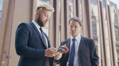 Modern ofis binasının önünde kendinden emin bir iş adamı ve meslektaşı. Finansal yatırımcılar dışarıda konuşuyorlar. Bankacılık ve iş.