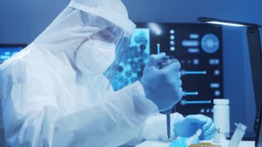 Koruyucu kıyafetli doktor modern bir laboratuvarda bilimsel deneyler yapıyor ve aşı geliştiriyor. Laboratuvar asistanı iş yerinde. Bilim ve tıp kavramı.