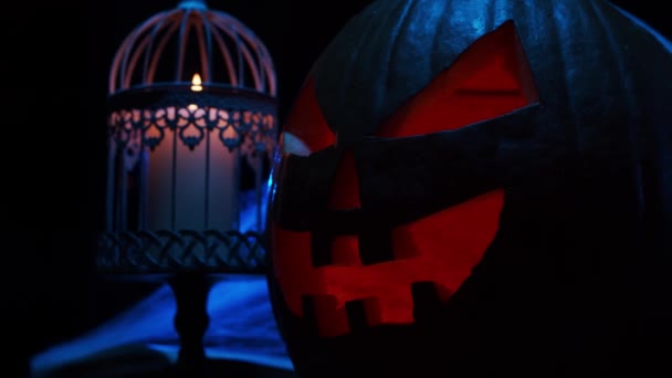 Scary laughing pumpkin and an old skull on a dark background. Halloween, witchcraft and magic. — Stock Video