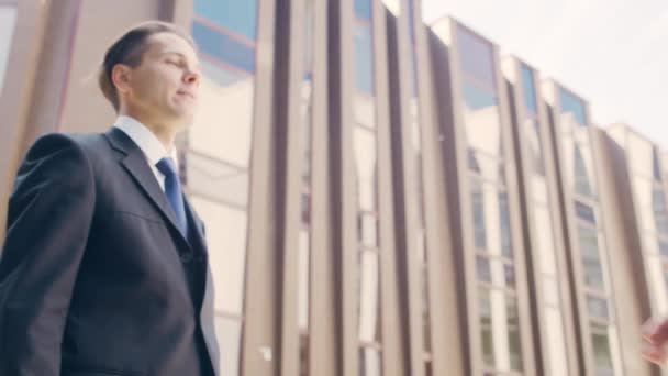 Homme d'affaires confiant et son collègue devant un immeuble de bureaux moderne. Les investisseurs financiers parlent en plein air. Banques et entreprises. — Video