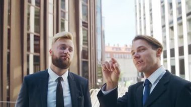 Modern ofis binasının önünde kendinden emin bir iş adamı ve meslektaşı. Finansal yatırımcılar dışarıda konuşuyorlar. Bankacılık ve iş.