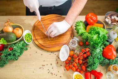 Genç aşçı modern bir mutfakta ahtapot kesiyor. Adam evde yemek hazırlıyor. Sağlıklı ve lezzetli yemekler pişirmek..