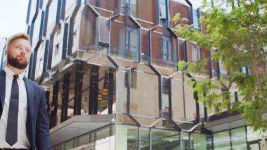 Modern ofis binasının önünde kendinden emin bir iş adamı. Finansal yatırımcı dışarıda dolaşıyor. Bankacılık ve iş.