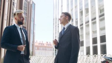 Modern ofis binasının önünde kendinden emin bir iş adamı ve meslektaşı. Finansal yatırımcılar dışarıda konuşuyorlar. Bankacılık ve iş.