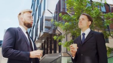 Modern ofis binasının önünde kendinden emin bir iş adamı ve meslektaşı. Finansal yatırımcılar dışarıda konuşuyorlar. Bankacılık ve iş.