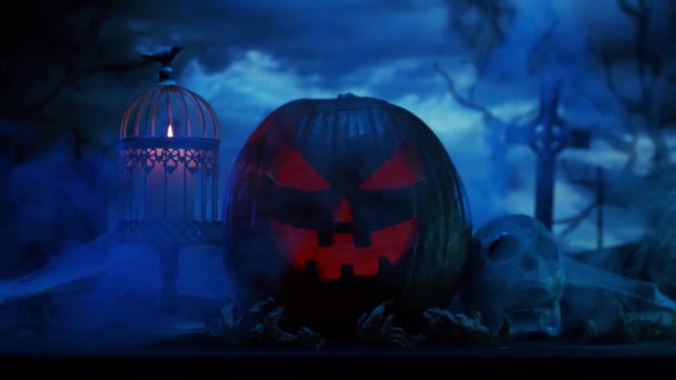 Calabaza riéndose de miedo y un viejo cráneo sobre el aterrador fondo del cementerio gótico. Halloween, brujería y magia. — Vídeo de stock