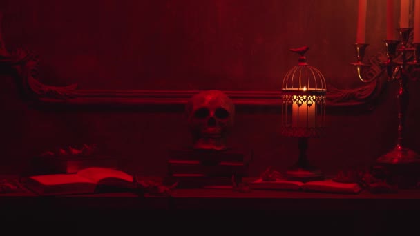 Mystischer Halloween-Stillleben-Hintergrund. Totenkopf, Leuchter mit Kerzen, alter Kamin. Horror und Hexerei. — Stockvideo