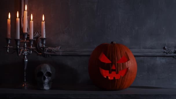 Scary laughing pumpkin and old skull on ancient gothic fireplace. Halloween, witchcraft and magic. — Stock Video