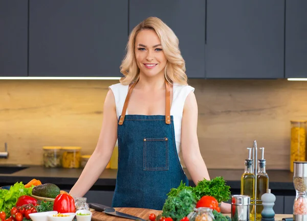 Jonge vrouw bereidt eten en organiseert een kookprogramma. De blogger stroomt vanuit de moderne keuken. Vegetarische gezonde voedselbereiding. — Stockfoto