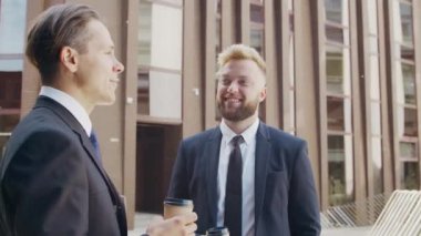 Modern ofis binasının önünde kendinden emin bir iş adamı ve meslektaşı. Finansal yatırımcılar dışarıda konuşuyorlar. Bankacılık ve iş.