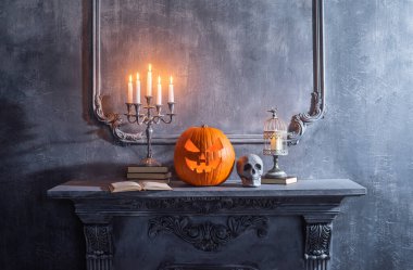 Korkunç gülen balkabağı ve eski kafatası antik gotik şöminede. Cadılar Bayramı, büyücülük ve sihir.