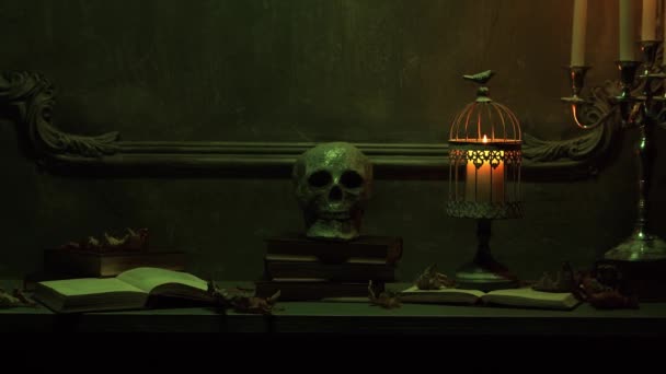 Mystieke Halloween stillevens achtergrond. Schedel, kandelaar met kaarsen, oude open haard. Horror en hekserij. — Stockvideo