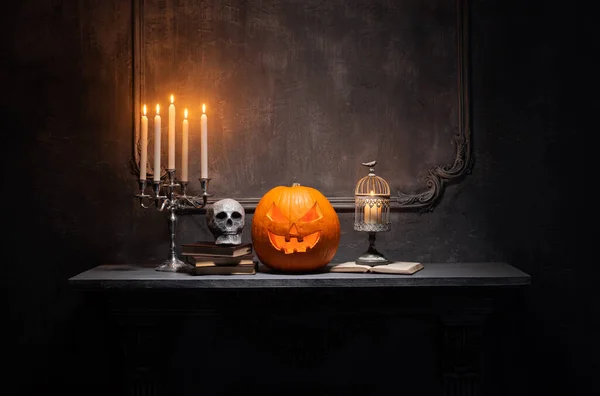 Calabaza riéndose de miedo y viejo cráneo en la antigua chimenea gótica. Halloween, brujería y magia. — Foto de Stock