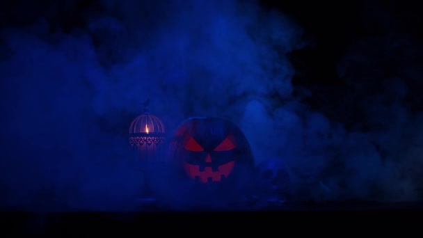 Děsivá dýně a stará lebka na tmavém pozadí. Halloween, čarodějnictví a magie. — Stock video