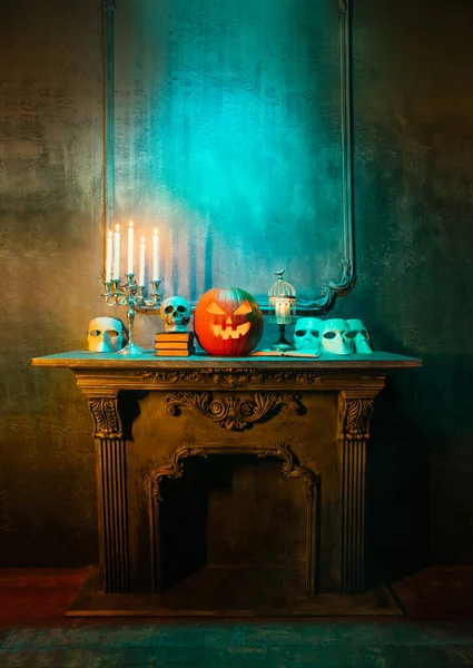 Läskigt skrattande pumpa och gammal skalle på antik gotisk öppen spis. Halloween, häxeri och magi. — Stockfoto