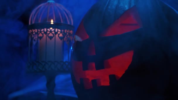 Abóbora risonha assustadora e um crânio velho num fundo escuro. Halloween, bruxaria e magia. — Vídeo de Stock