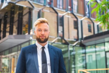 Modern ofis binasının önünde kendinden emin bir iş adamı. Finansal yatırımcı dışarıda dolaşıyor. Bankacılık ve iş.