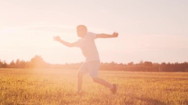 Gün batımında tarlada bir çocuk. Çocukluk, özgürlük ve ilham konsepti.