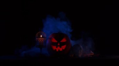 Korkunç, gülen bir balkabağı ve karanlık bir arka planda eski bir kafatası. Cadılar Bayramı, büyücülük ve sihir.