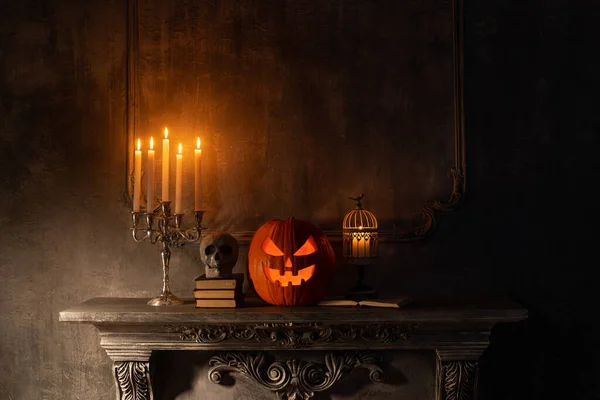 Calabaza riéndose de miedo y viejo cráneo en la antigua chimenea gótica. Halloween, brujería y magia. — Foto de Stock