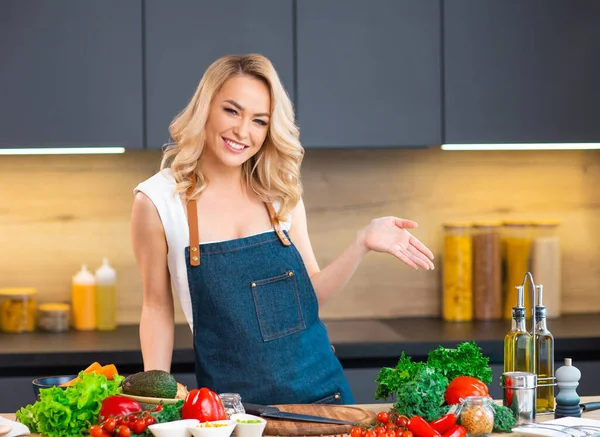 Jonge vrouw bereidt eten en organiseert een kookprogramma. De blogger stroomt vanuit de moderne keuken. Vegetarische gezonde voedselbereiding. — Stockfoto