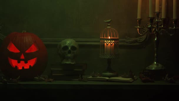 Calabaza riéndose de miedo y viejo cráneo en la antigua chimenea gótica. Halloween, brujería y magia. — Vídeo de stock