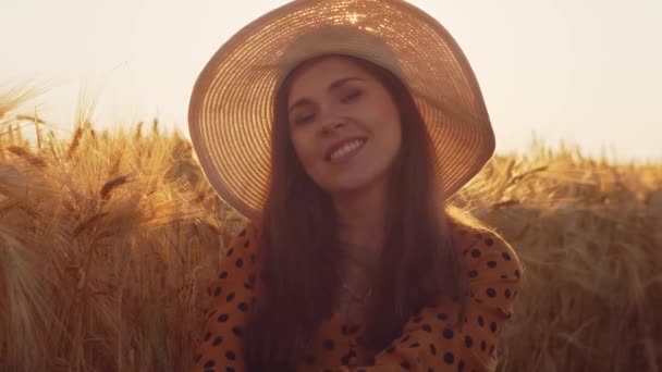 Gros plan portrait de belle jeune femme dans un champ. Visage féminin dans les rayons du coucher du soleil. Concept de liberté et de bonheur. — Video