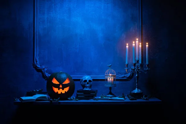 Läskigt skrattande pumpa och gammal skalle på antik gotisk öppen spis. Halloween, häxeri och magi. — Stockfoto