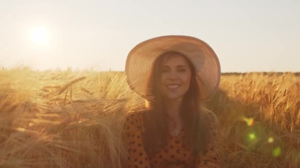 Gros plan portrait de belle jeune femme dans un champ. Visage féminin dans les rayons du coucher du soleil. Concept de liberté et de bonheur. — Video