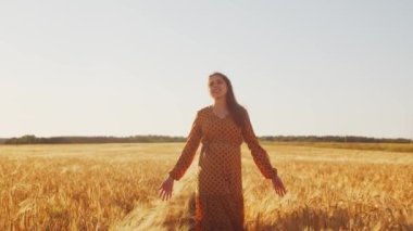 Günbatımında hamile bir kadın. Güzel bir genç kız bir çocuğun doğmasını umarak tarlada yürüyor. Annelik ve hamilelik kavramı.