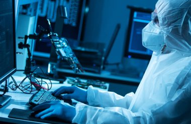 Bilim adamı mikro elektronik ve işlemcilerin araştırılması ve geliştirilmesi için modern bir bilim laboratuvarında çalışıyor. Mikroişlemci imalat işçisi bilgisayar teknolojisi ve ekipmanı kullanıyor.