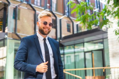 Modern ofis binasının önünde kendinden emin bir iş adamı. Finansal yatırımcı dışarıda dolaşıyor. Bankacılık ve iş.