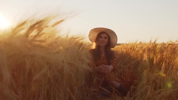Πορτρέτο της όμορφης νεαρής γυναίκας σε ένα πεδίο υπαίθρου. Γυναικείο πρόσωπο στις ακτίνες του ηλιοβασιλέματος. Φρίντομ και ευτυχία. — Αρχείο Βίντεο