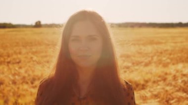 Tarladaki güzel genç bir kadının yakın plan portresi. Gün batımında kadın yüzü. Freedome ve mutluluk konsepti.